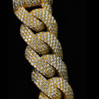 A close-up of the Diamond Cuban Link Chain - Semi Solid - 16mm, crafted in 10k gold and encrusted with small lab-grown diamonds, set against a black background.