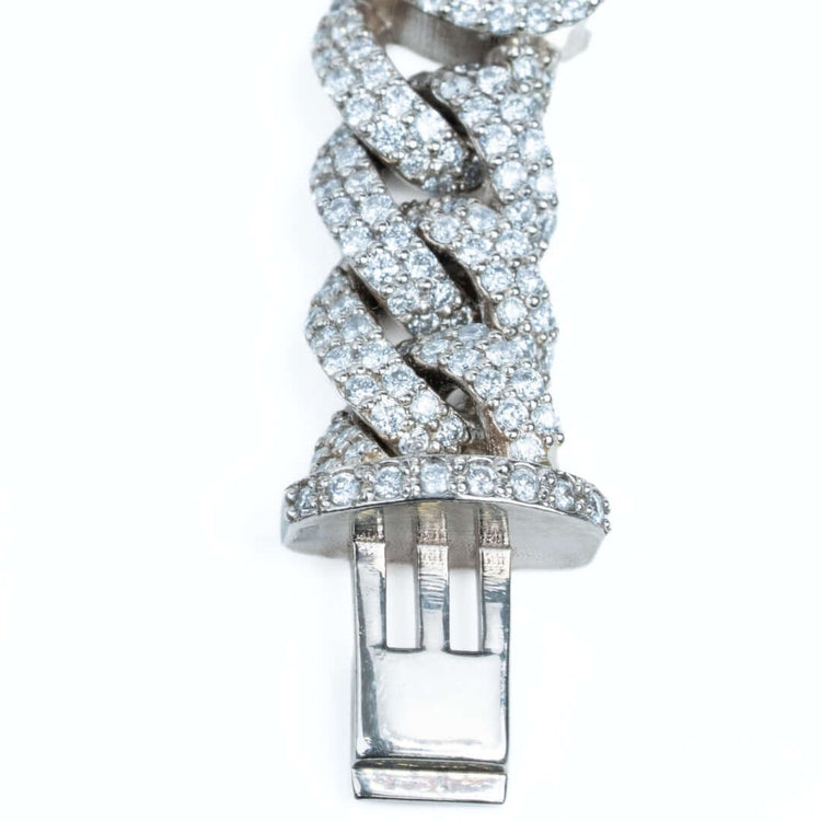 A close-up of the Diamond Heart Cuban Link Bracelet showing its interwoven links adorned with small diamonds and finished with a silver clasp.