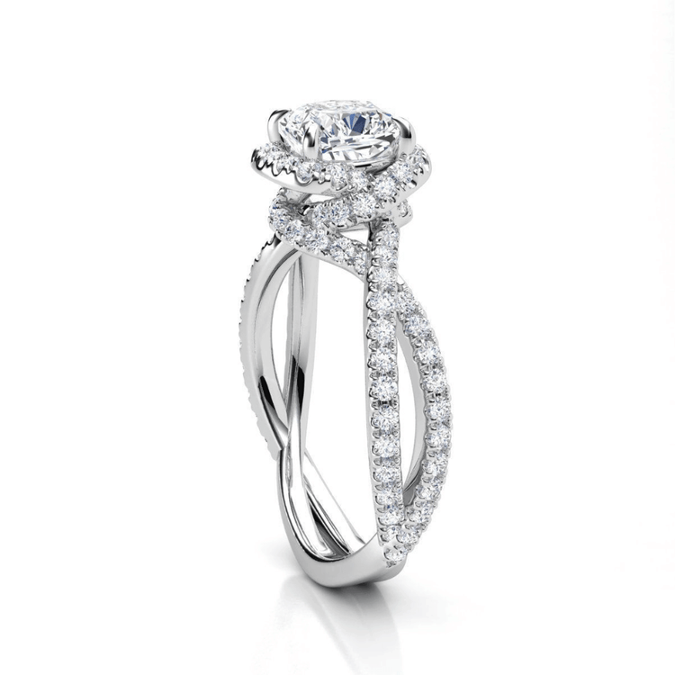 The Elegant Twisted Halo Lab Diamond Ring features a cushion-cut center stone set above a twisted band with pavé diamonds, displayed on a white background.
