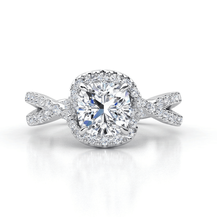 The Elegant Twisted Halo Lab Diamond Ring showcases a cushion-cut center stone, haloed by lab diamonds, on a twisted white gold band also set with sparkling stones.