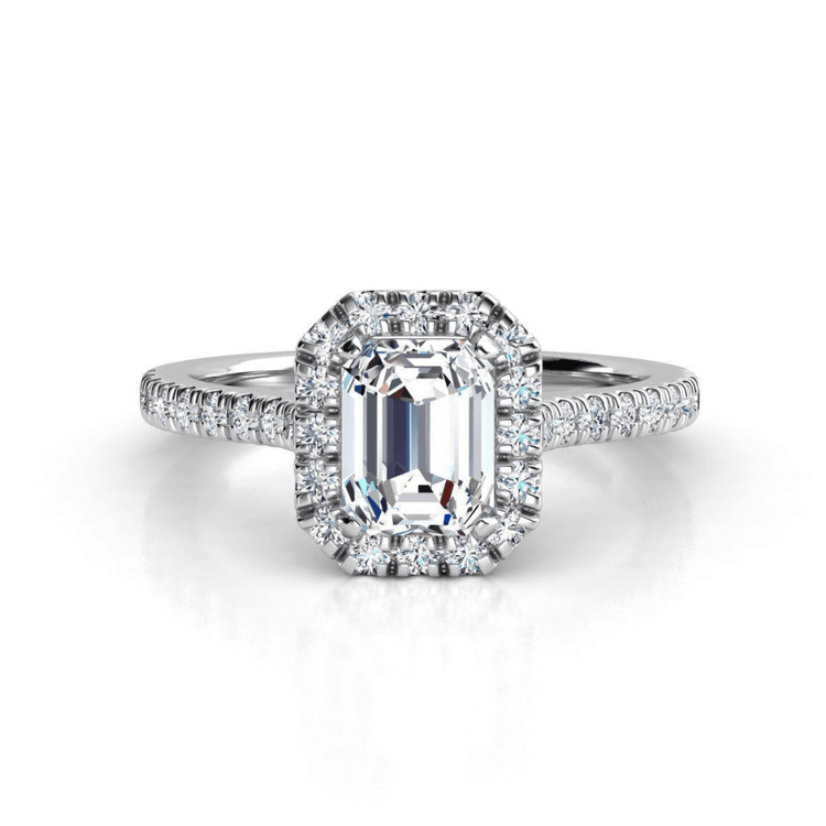 The Emerald-Cut Halo Lab Diamond Engagement Ring with Pavé Band, set in white gold or platinum, features an emerald-cut lab diamond surrounded by a diamond halo and pavé band, displayed on a white background.