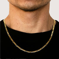 A close-up of a person wearing the Figaro Chain 4.5mm – Solid Yellow Gold over a black shirt, with the lower part of their face and neck visible.