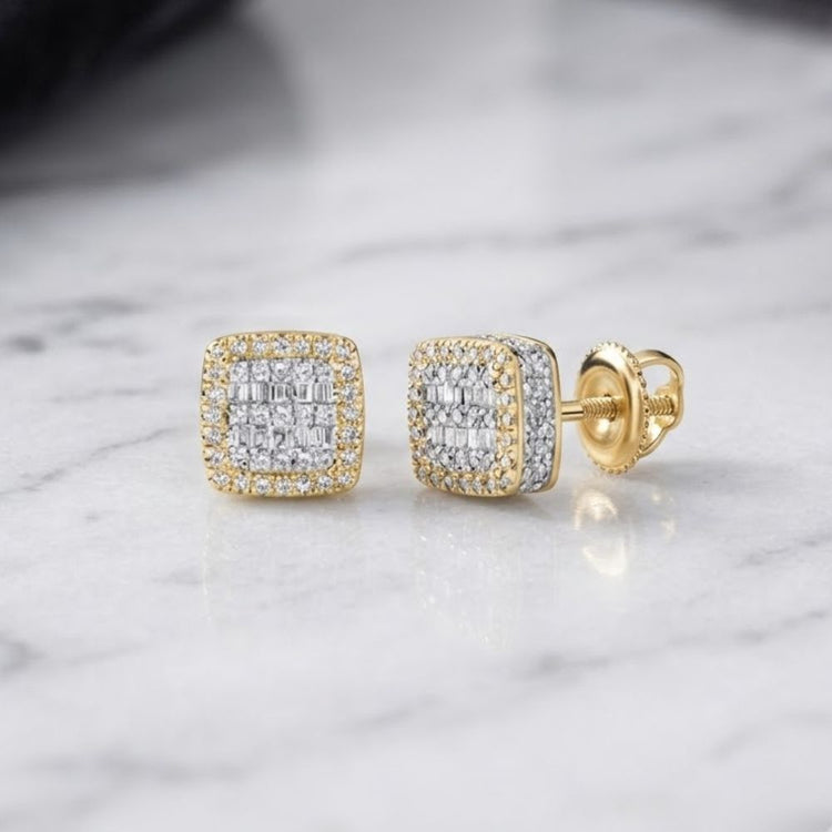 The 10K Yellow Gold Baguette Diamond Square Earrings, featuring a geometric design with sparkling diamonds and a secure screw-back closure, are crafted in 10K yellow gold and displayed on a marble surface.