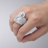 A hand displays the Baguette 2.1ct Moissanite Jesus Religious Ring, a sterling silver piece featuring an embossed haloed figure and sparkling baguette moissanite stones against a plain background.