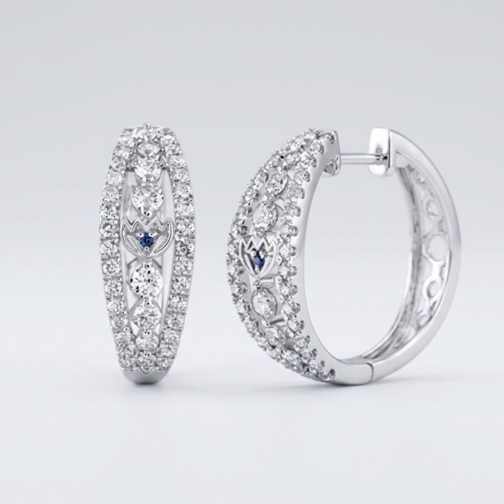 The 14k White Gold Diamond Hoop Earrings (1-1/4 Cttw) feature sparkling diamonds with small blue accents, shown on a light gray background.