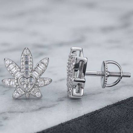 Sterling Silver Moissanite Leaf Stud Earrings are displayed on a gray marble surface with a partial black accent. A chic addition to women’s fashion jewelry collections.