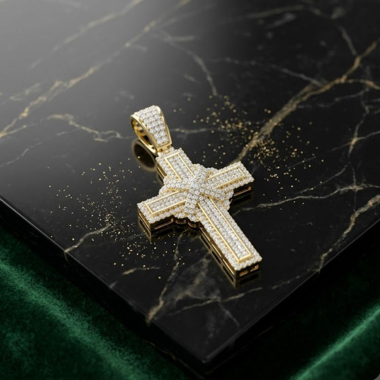 The 10K Yellow Gold Diamond Cross Pendant 7/8CTW, adorned with natural diamonds, lies on black marble with gold veins, surrounded by glittering accents as green velvet appears at the bottom edge.