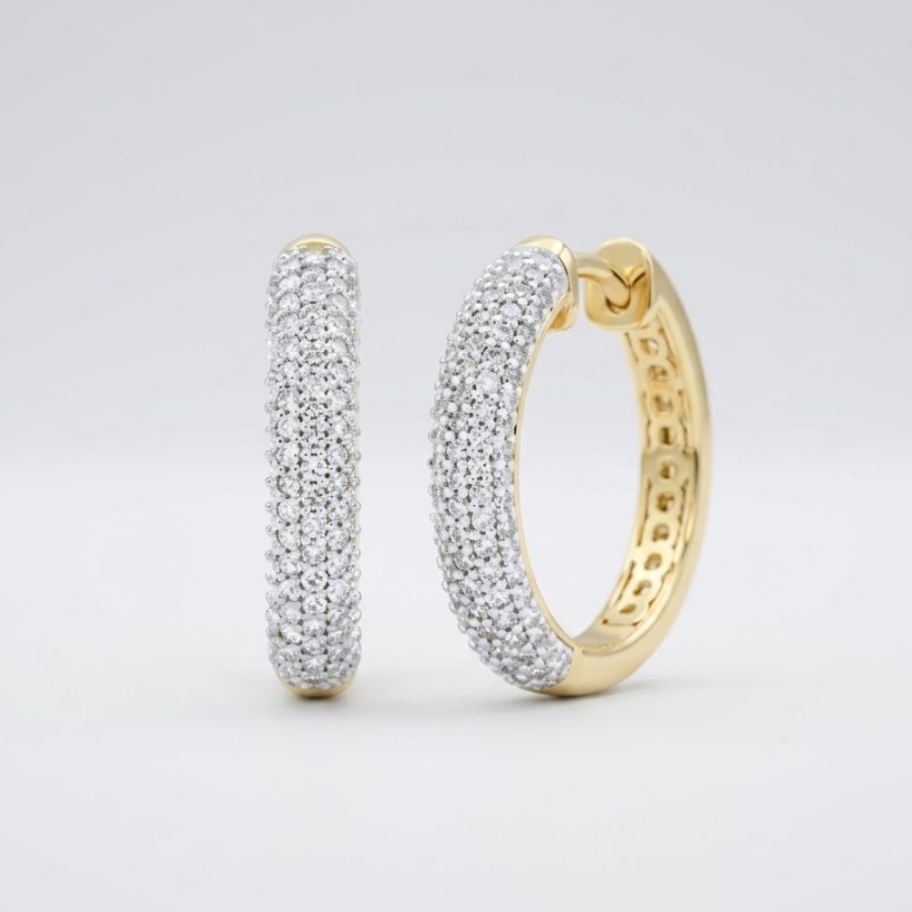 The 3/4CTW Diamond Hoop Earrings in 10k yellow gold feature rows of sparkling diamonds, beautifully displayed against a plain light gray background.