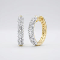 The 3/4CTW Diamond Hoop Earrings in 10k yellow gold feature rows of sparkling diamonds, beautifully displayed against a plain light gray background.