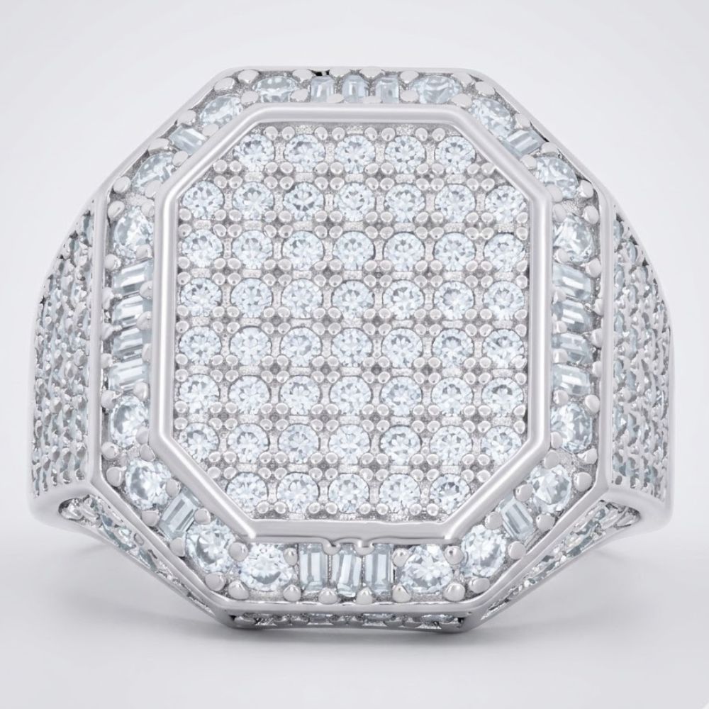 The Round Moissanite Octagon Head Fashion Ring features a silver octagon head densely set with round and baguette moissanites in a sparkling geometric pattern, with the band also embellished with rows of dazzling stones.