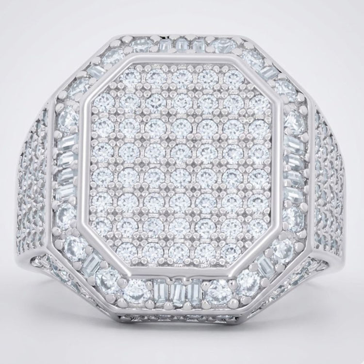 The Round Moissanite Octagon Head Fashion Ring features a silver octagon head densely set with round and baguette moissanites in a sparkling geometric pattern, with the band also embellished with rows of dazzling stones.