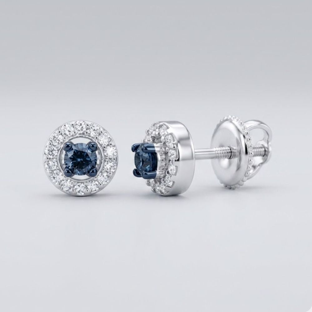 The 10k White Gold Blue Diamond Halo Earrings 1/5 Cttw showcase a central dark blue diamond framed by clear diamonds in round halos, set in white gold with screw-back posts, shown on a light gray background.