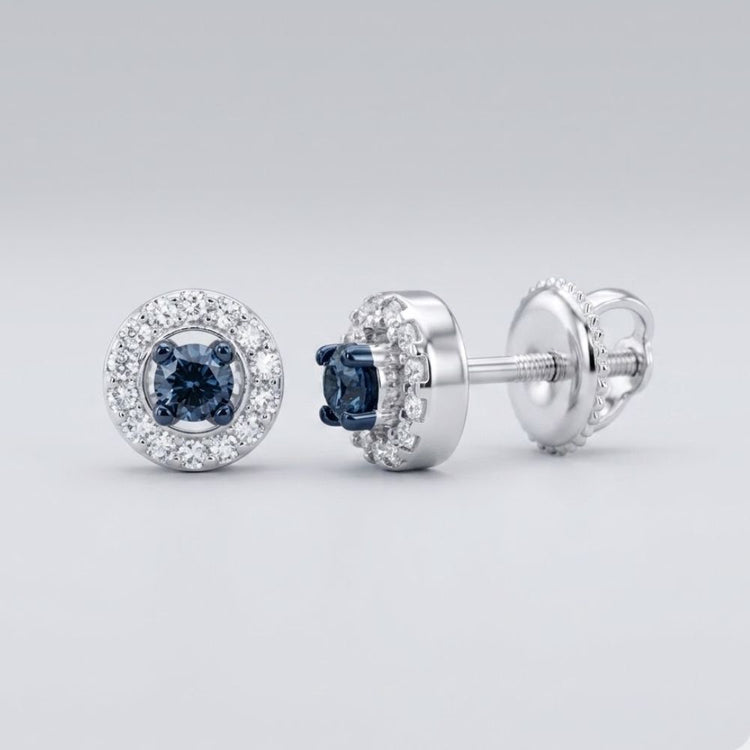 The 10k White Gold Blue Diamond Halo Earrings 1/5 Cttw showcase a central dark blue diamond framed by clear diamonds in round halos, set in white gold with screw-back posts, shown on a light gray background.