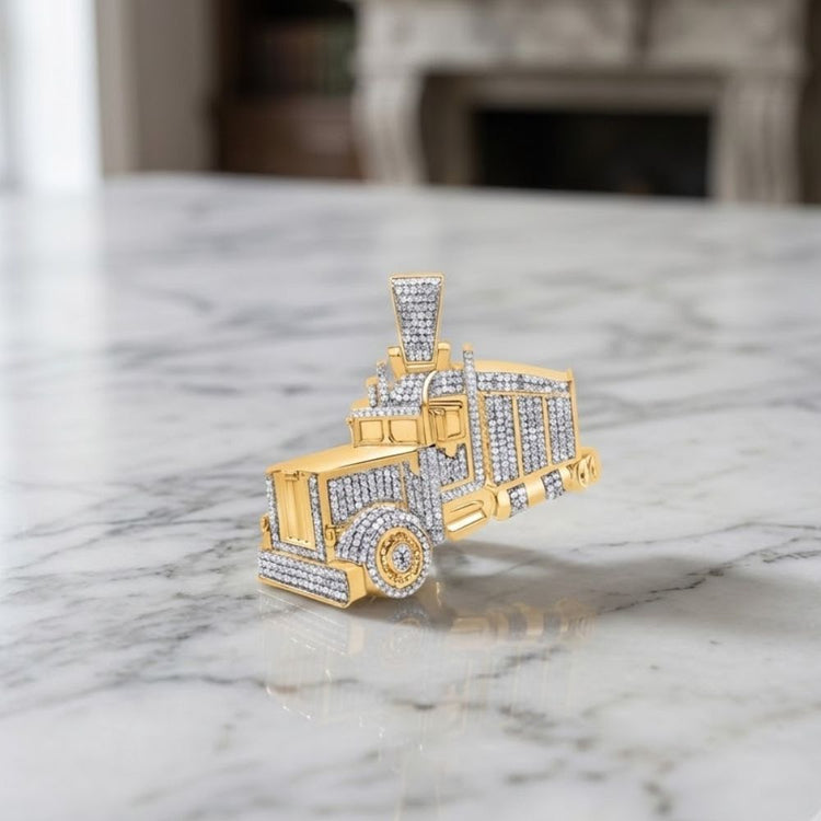 A 1CTW diamond truck charm shaped like a semi-truck rests on a marble surface, with furniture softly blurred in the background. This eye-catching men’s pendant from P3 Diamond Jewelry features natural diamonds set in sterling silver, combining bold design with refined luxury.