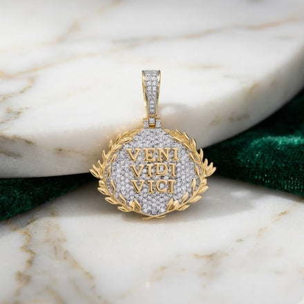 The 10K Gold Diamond Veni Vidi Vici Charm 7/8 CTW features VENI VIDI VICI in gold letters framed by a laurel wreath—a refined men’s diamond pendant from our natural diamond jewelry collection, showcased on marble.