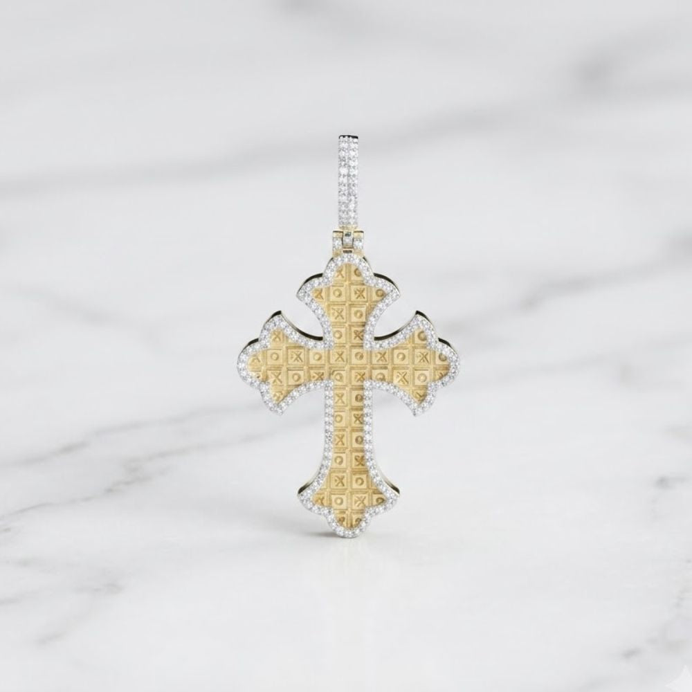 The 3/8CTW Natural Diamond Cross Mens Charm in 10K gold, featuring an ornate cross with a border of sparkling diamonds, is displayed upright on a white marble surface.