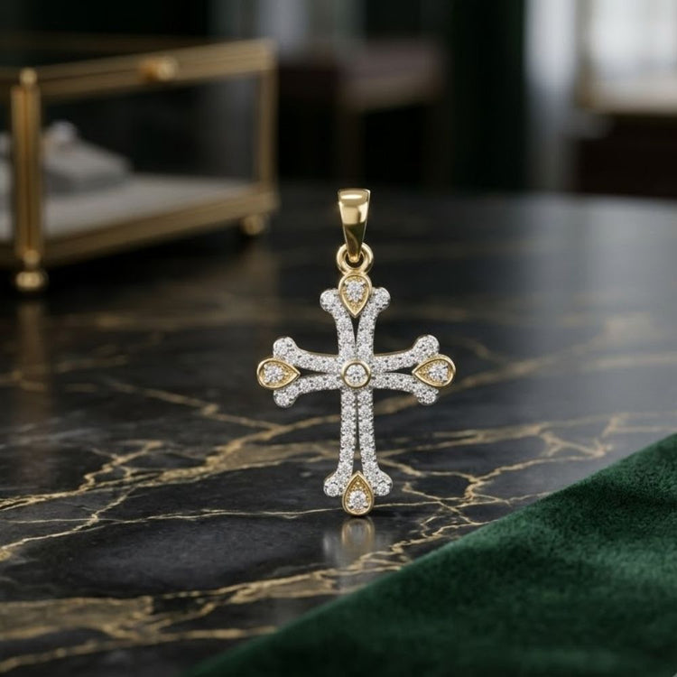 The 1/4CTW Diamond Cross Pendant in 10K Yellow Gold rests on a dark marble surface, its sparkling diamonds and gold accents shining, while a blurred jewelry box sits in the background.