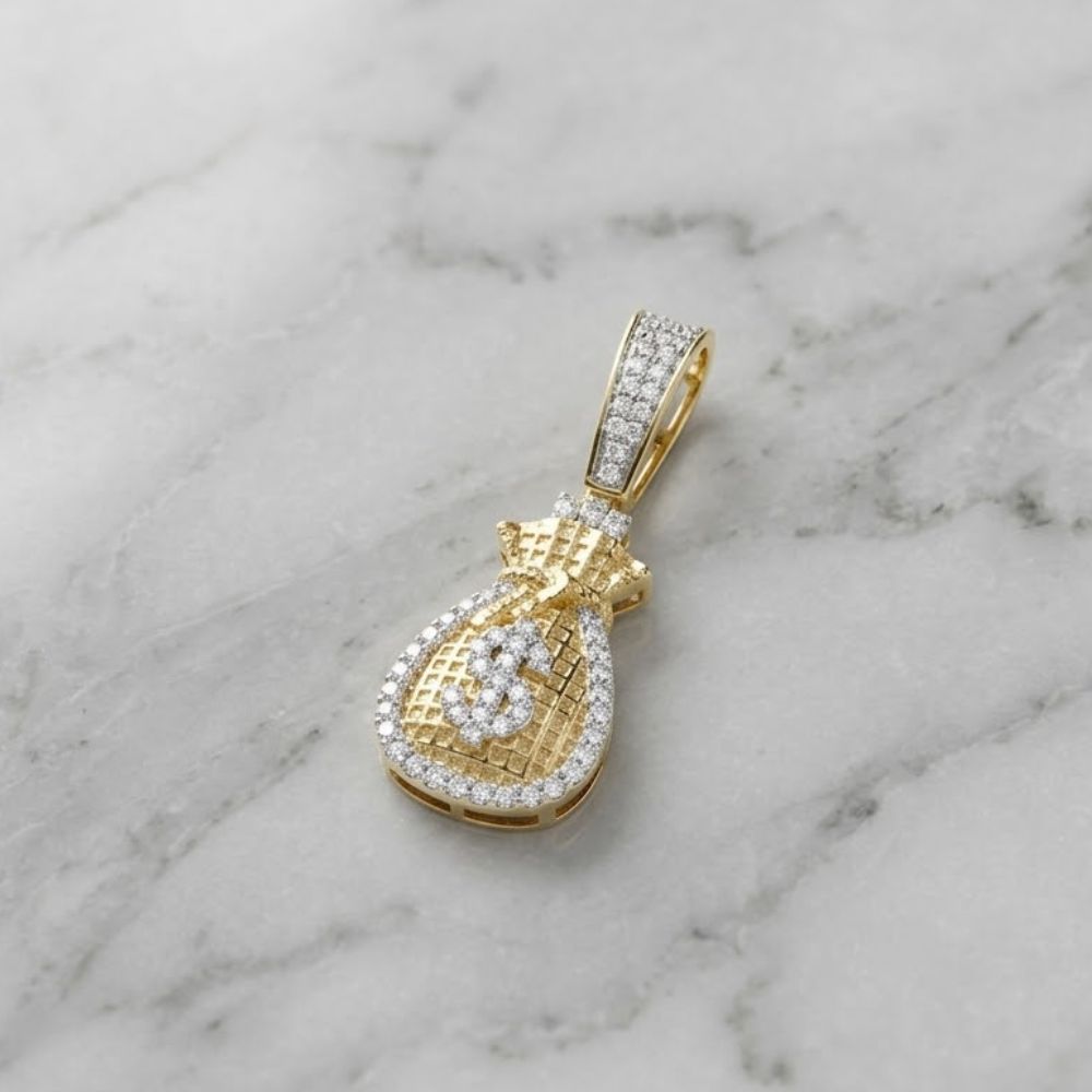 The Diamond Money Bag Charm 1/4 CTW in 10K gold, featuring a dollar sign and sparkling diamonds, is a stylish men’s pendant shown on a white marble surface.
