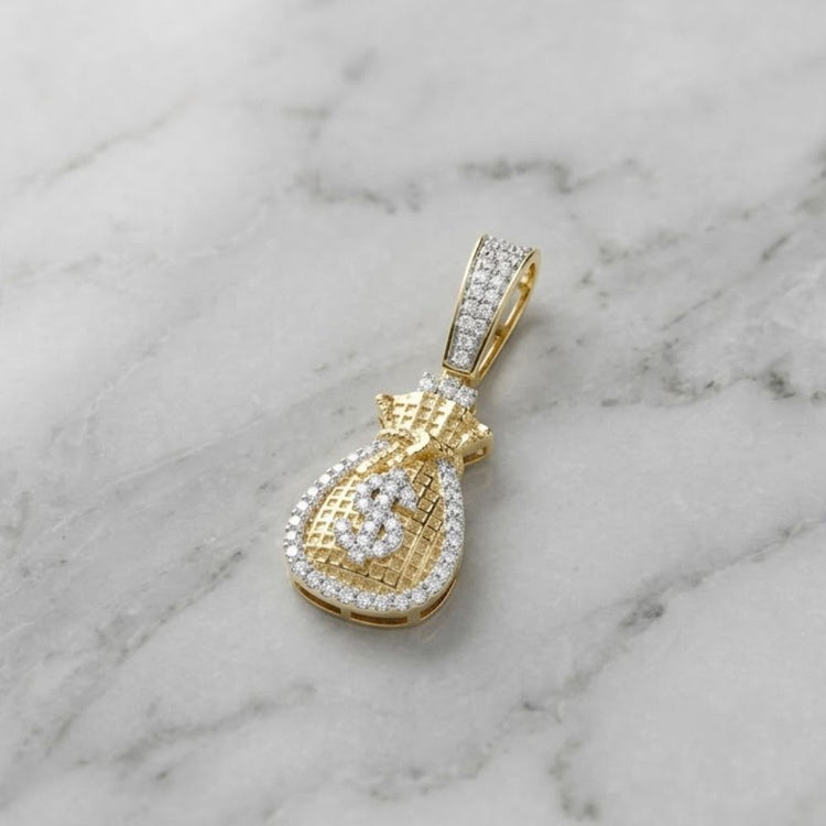 The Diamond Money Bag Charm 1/4 CTW in 10K gold, featuring a dollar sign and sparkling diamonds, is a stylish men’s pendant shown on a white marble surface.