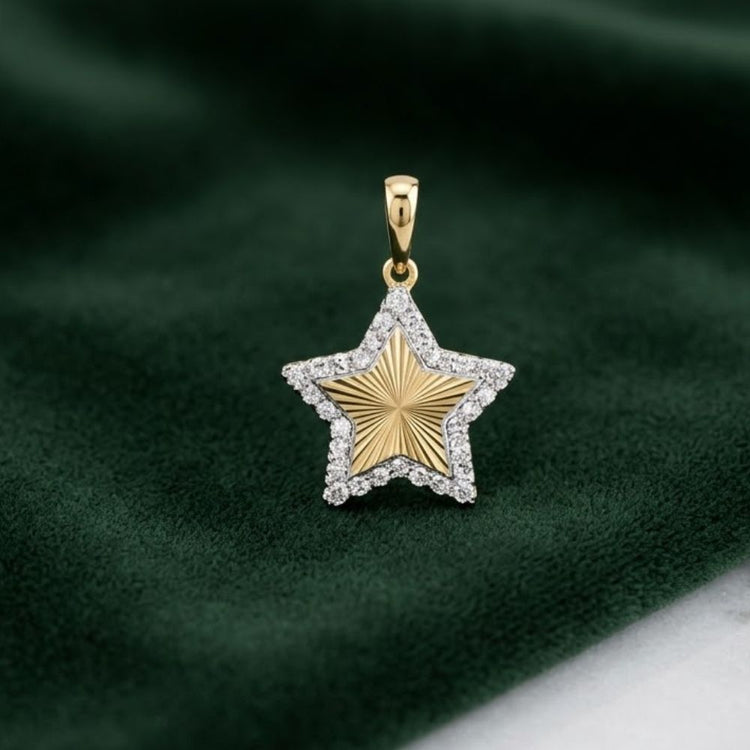 The 1/6CTW Natural Diamond Star Pendant in 10K gold, with a textured center and diamond-studded border, is displayed on deep green velvet.