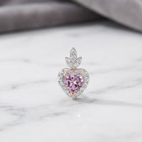 The 1/6 CTW Rose Gold Diamond Morganite Heart Pendant 4.5mm features a pink morganite center, sparkling diamond accents, and marquise stones, beautifully displayed on a white marble surface.