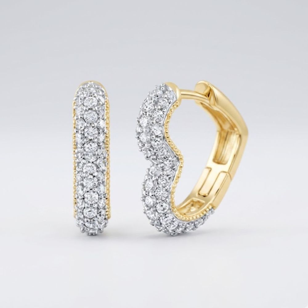The 14k Yellow Gold Heart Diamond Hoop Earrings 3/4CTW are pictured on a light gray background, with one earring upright and the other horizontal and slightly open to display their sparkling diamond accents.