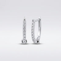 A pair of 10k Gold Round Diamond Hoop Earrings (1/12 Cttw) with slim silver hoops and sparkling diamonds along the front, shown on a plain light gray background.