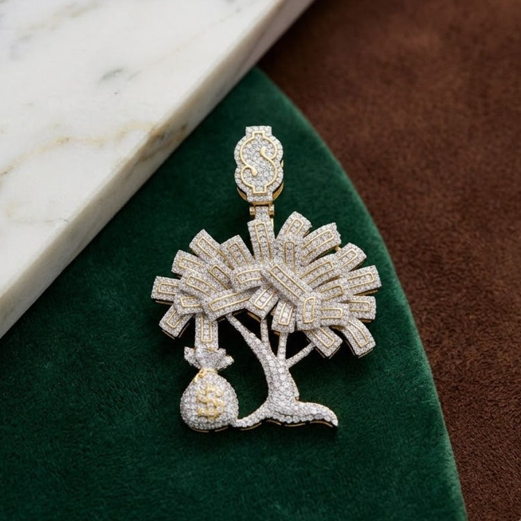 The 10K Gold Diamond Money Tree Charm Pendant (2.75 CTW) features a palm tree with crossed swords and a money bag—an ideal hip hop jewelry piece, shown on green and brown fabric beside white marble.