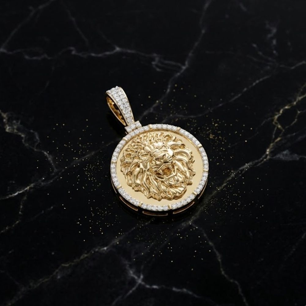 The Diamond Lion Face Charm 1/4CT in 10K gold, featuring a raised lion’s head and encircled by shimmering diamonds, is displayed on a black marble surface dusted with gold specks.