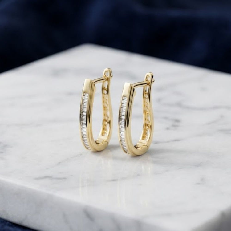 10K Yellow Gold Baguette Diamond Hoop Earrings displayed on a marble surface.