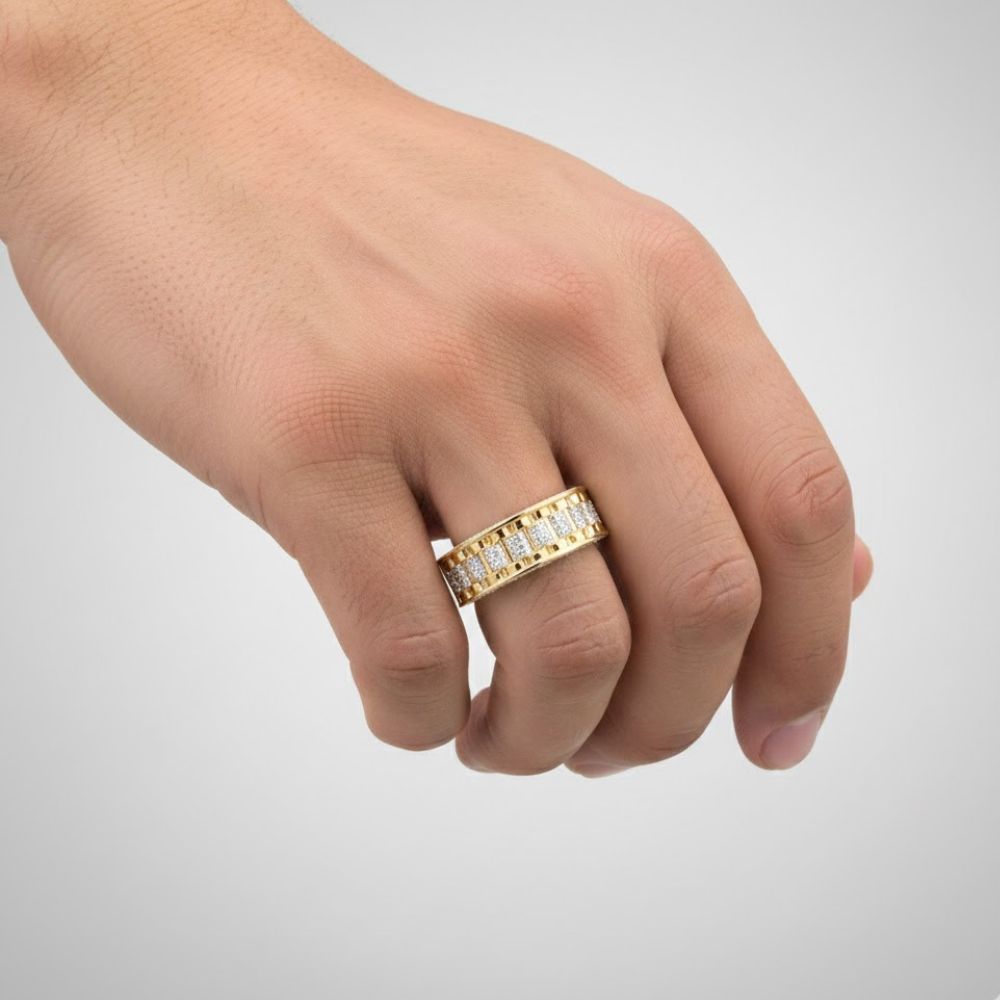A hand wears the 3/8 CTTW Natural Diamond Men’s Band in 14K gold, featuring a row of rectangular clear diamonds, shown against a plain light gray background.