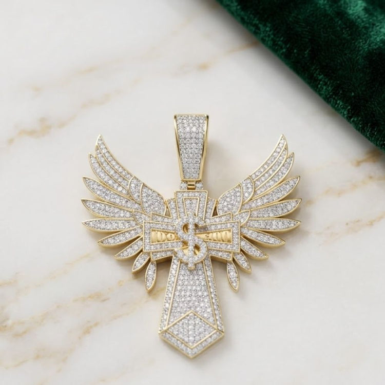 The 10K Gold Diamond Dollar Cross Charm 1.75 CTW, a standout men’s jewelry piece, features diamonds on a gold cross pendant with angel wings, displayed on marble beside green fabric.