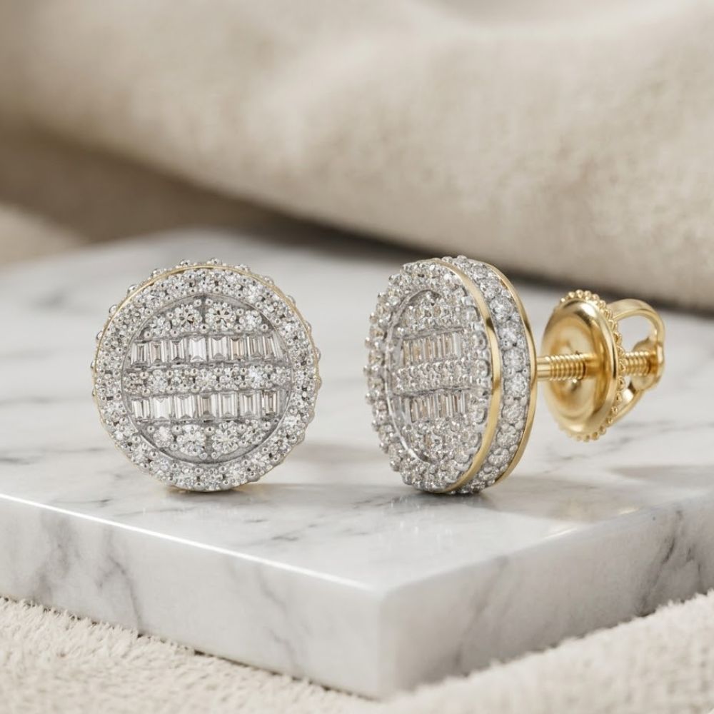 The 3/4CTW Baguette Diamond Circle Earrings in 10K Gold showcase intricate baguette and round diamond designs, elegantly displayed on a white marble slab with a soft, neutral backdrop.