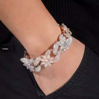 A hand in a black pocket wears the Silver Moissanite Flower Infinity Bracelet, featuring sparkling flower and infinity designs.