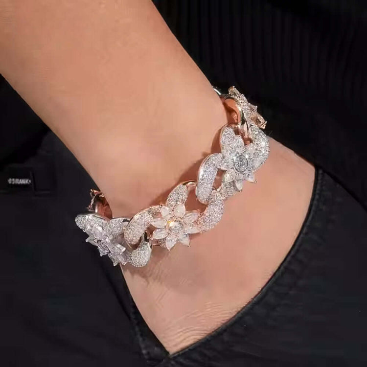 A hand in a black pocket wears the Silver Moissanite Flower Infinity Bracelet, featuring sparkling flower and infinity designs.
