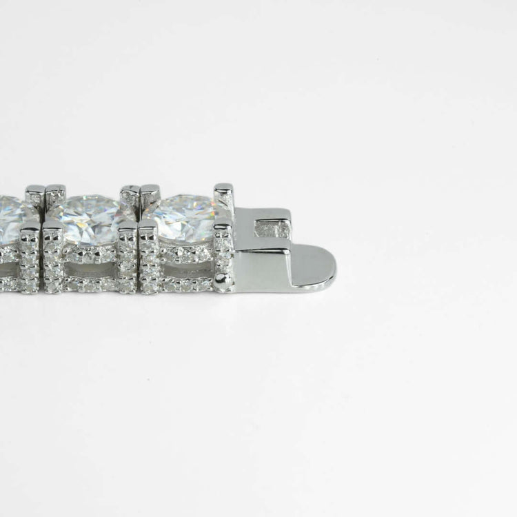 A close-up of a 925 sterling silver clasp on the Fully Iced Out Moissanite Tennis Bracelet, featuring large round clear gemstones and small sparkling stones, set against a plain white background.