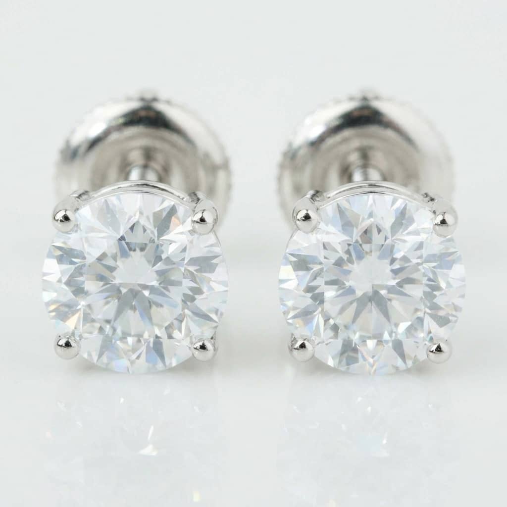 The 14k Classic Round Lab Diamond Four Prong Stud Earrings (F/G VS+) feature secure screw-back posts and a four-prong 14K white gold setting, shown on a white background.