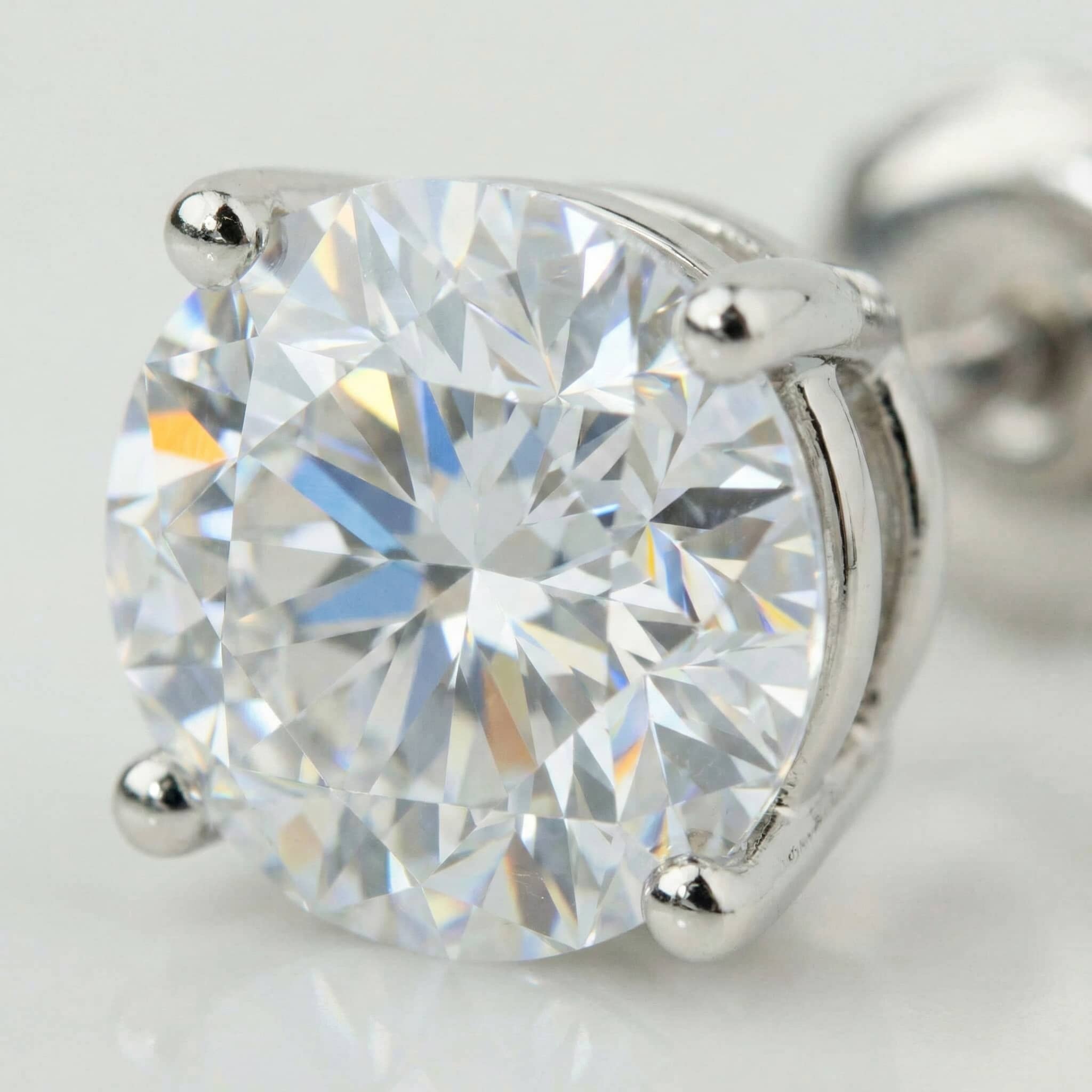 Close-up of the 14k Classic Round Lab Diamond Four Prong Stud Earring (F/G VS+), featuring a sparkling round lab diamond in a four-prong 14K white gold setting that reflects colorful light.