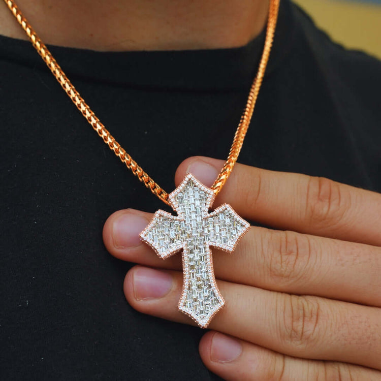 A person wearing a gold chain with the Gothic Lab Diamond Cross Pendant holds the sparkling pendant against their black shirt.