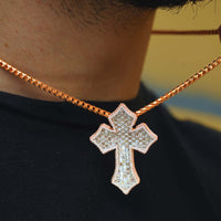 A close-up of a person wearing the Gothic Lab Diamond Cross Pendant, a striking 14k gold necklace featuring a large diamond cross, displayed against a black shirt.