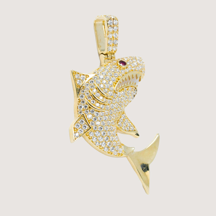 The 14k Gold Great White Shark Pendant – Men’s Gold Pendant features sparkling cubic zirconia stones and a single red gemstone eye, set against a plain background—a striking choice for those seeking bold shark-inspired jewelry.