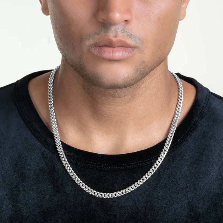 A person in a black shirt wears the Hollow White Gold Cuban Link Chain (3mm - 7mm), shown from the shoulders up with a neutral expression against a plain light background.