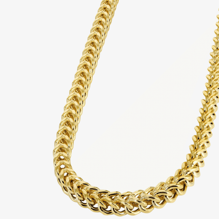 A close-up of the Franco Chain - 2mm-7mm Hollow Yellow Gold, featuring interlocking links in a V-shape, displayed against a plain white background.