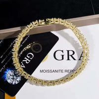 The Iced Out Moissanite Tennis Bracelet - 5mm, featuring gold square links encrusted with clear stones, is displayed in a circle on a card labeled GR and MOISSANITE REPORT.