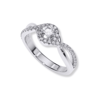 The Infinity Halo Lab Diamond Engagement Ring is a silver ring showcasing a round lab diamond, encircled by an infinity halo of smaller diamonds and a twisting band accented with sparkling stones.