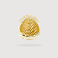 The Mason Ring – Solid 10k Gold is displayed from the underside, highlighting its honeycomb-patterned inner surface set against a light gray background.