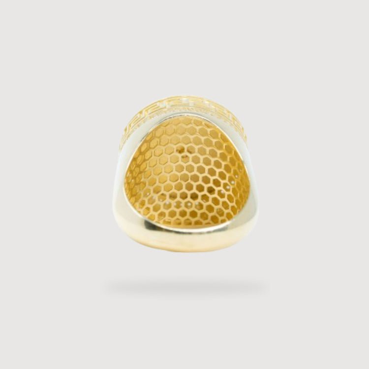 The Mason Ring – Solid 10k Gold is displayed from the underside, highlighting its honeycomb-patterned inner surface set against a light gray background.
