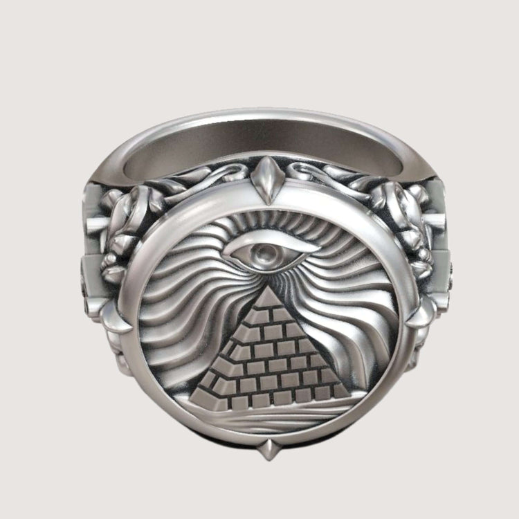 The Masonic All-Seeing Eye Pyramid Illuminati Ring is a silver piece with an engraved pyramid, All-Seeing Eye above it, and decorative swirling patterns with raised details.
