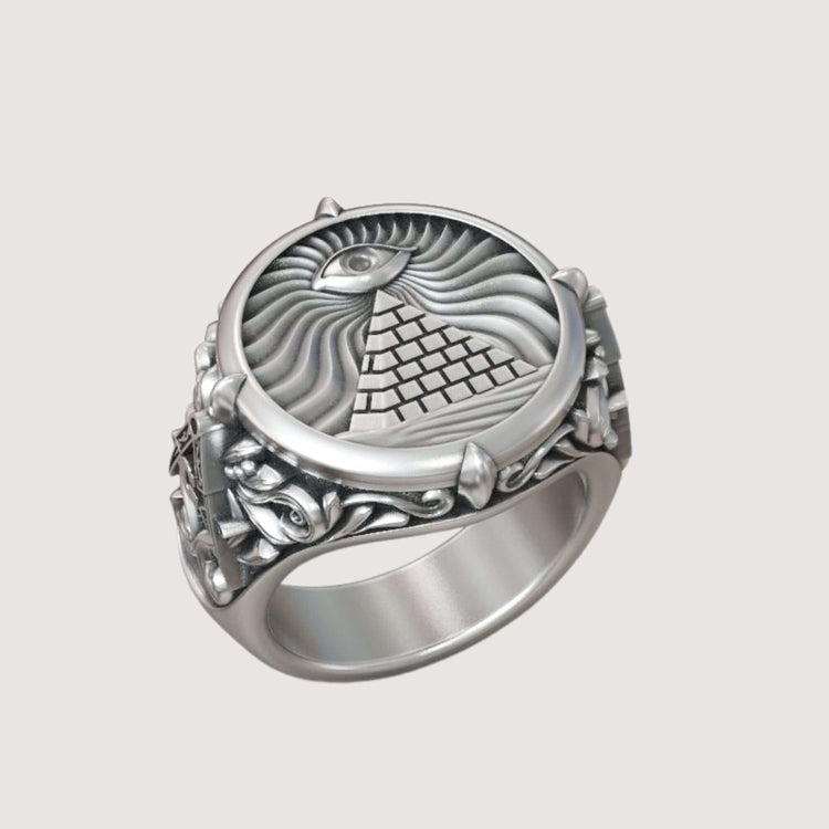 The Masonic All-Seeing Eye Pyramid Illuminati Ring features a silver band with an engraved pyramid, the All-Seeing Eye above it, radiating lines in the background, and ornate designs on the band.