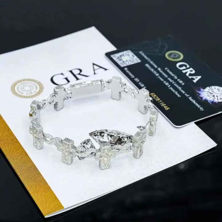 The Moissanite Cross Bracelet – 925 Sterling Silver, featuring sparkling cross-shaped charms, is showcased atop a GRA certificate and authenticity card on a sleek black surface.